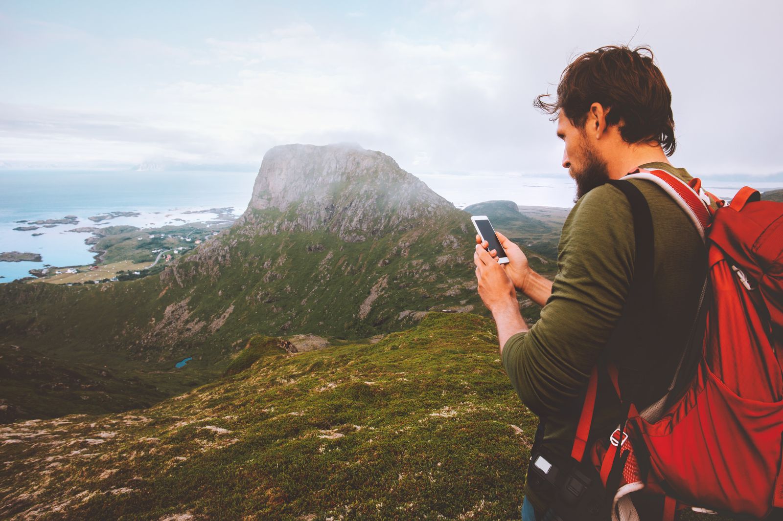 Man with phone monitoring the flock from the mountain